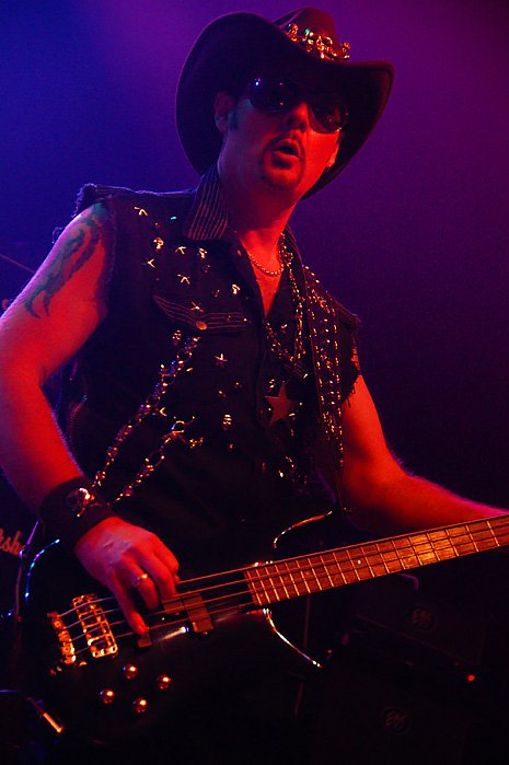 Basist med cowboy hat och nitväst.