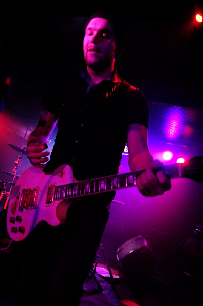 En gitarrist i svart skjorta.