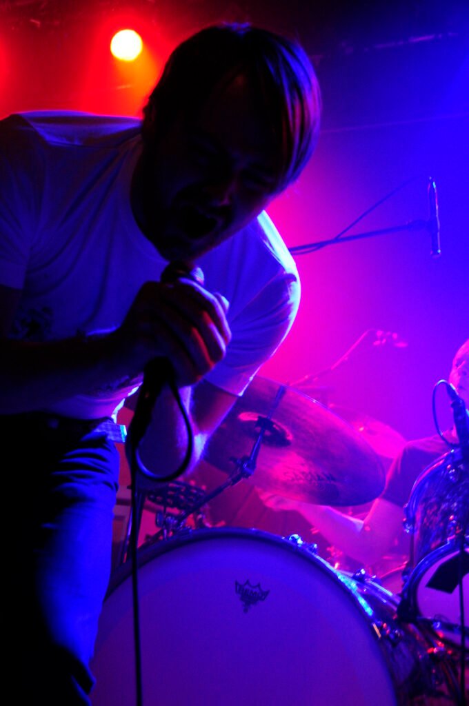 Konturer av en sångare i vit t-shirt.